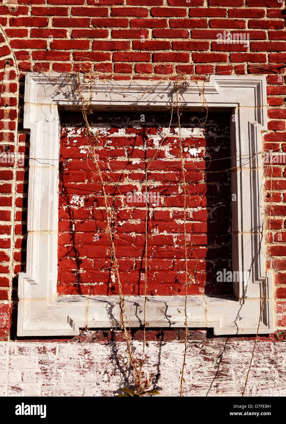 Einen leeren weißen Holzrahmen auf rotem Lehm Wand, draußen in der Sonne. Stockfoto