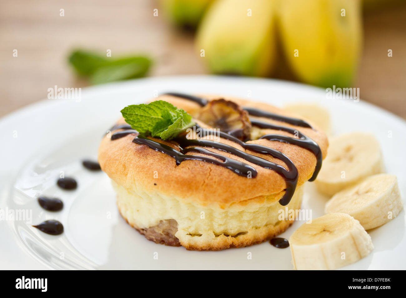 Käsekuchen mit Bananen in Schokolade mit Minze Stockfoto