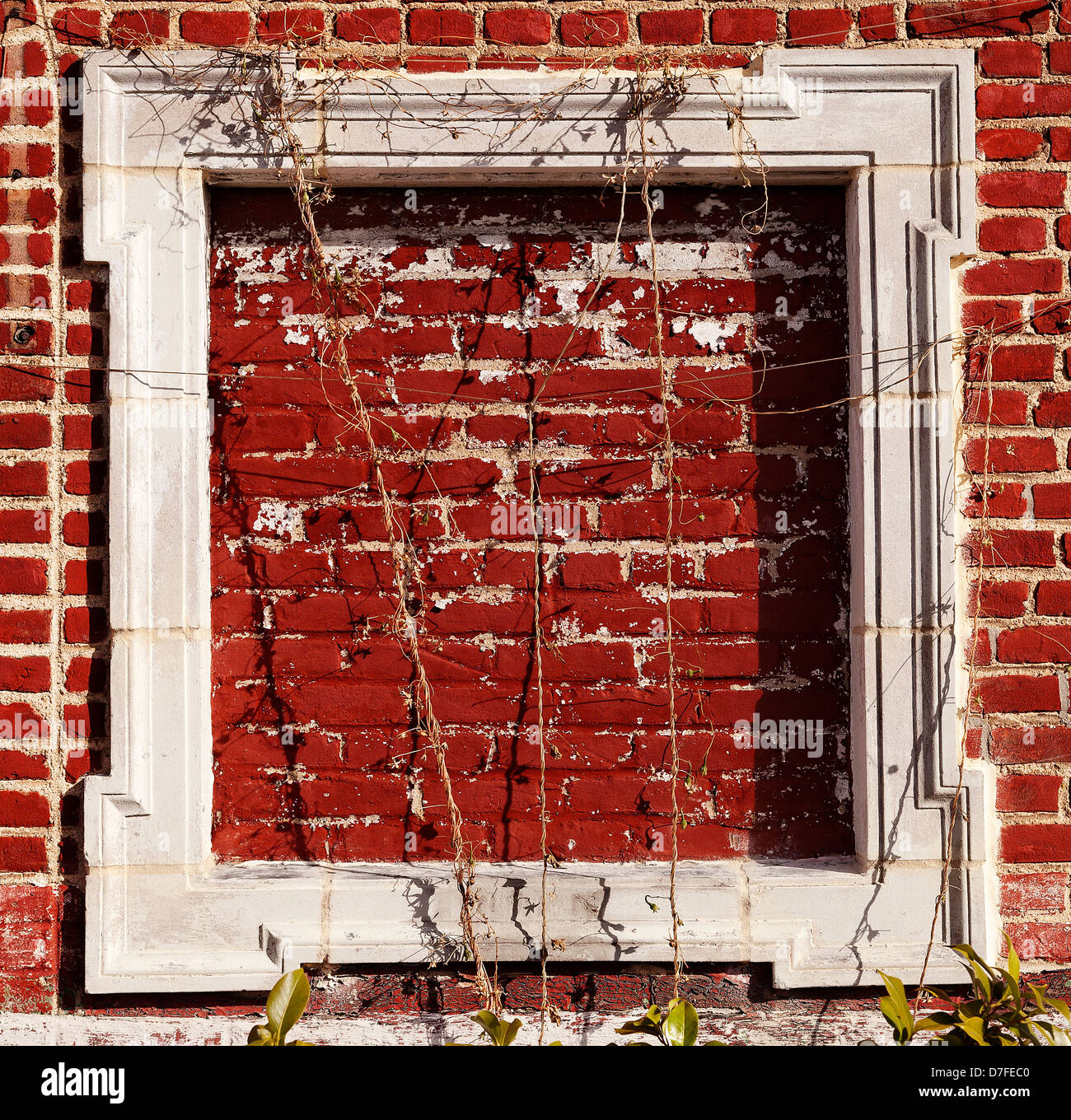 Einen leeren weißen Holzrahmen auf rotem Lehm Wand, draußen in der Sonne. Stockfoto