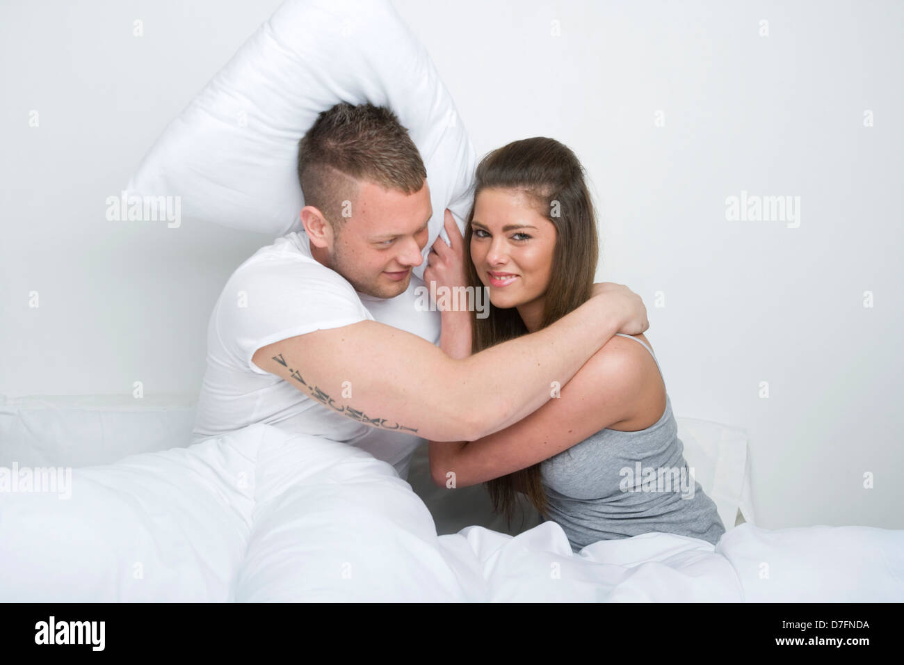 Junges Paar spielen im Bett kämpfen. Stockfoto