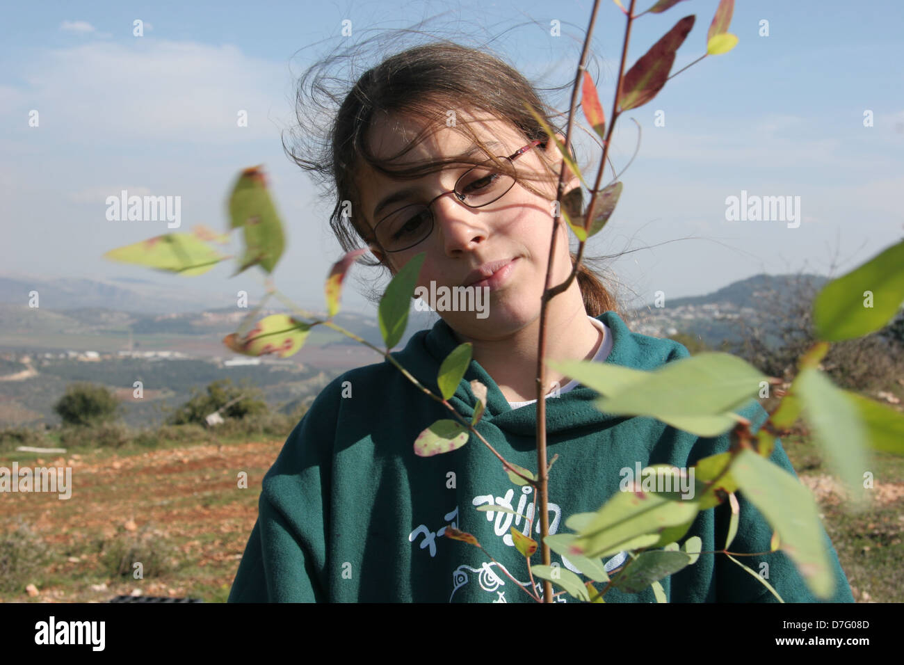 Mädchen mit einer Pflanze auf Tu bishvat Stockfoto