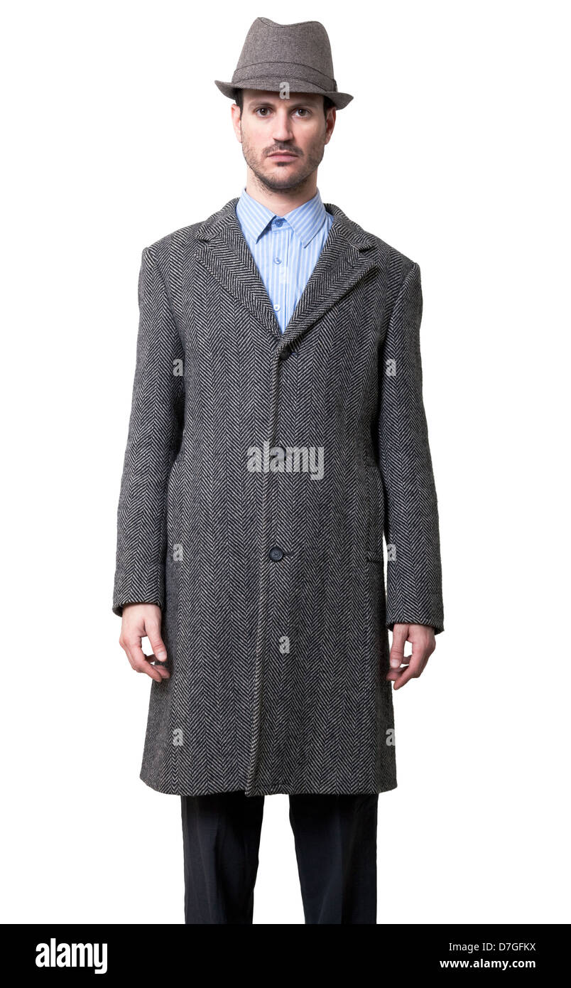 Ein junger Erwachsener Mann gekleidet in grauen Mantel grau Hut 30er Jahre  Stil auf der Suche direkt auf der Kamera einfach Gesicht Hände neben seinen  Körper Stockfotografie - Alamy