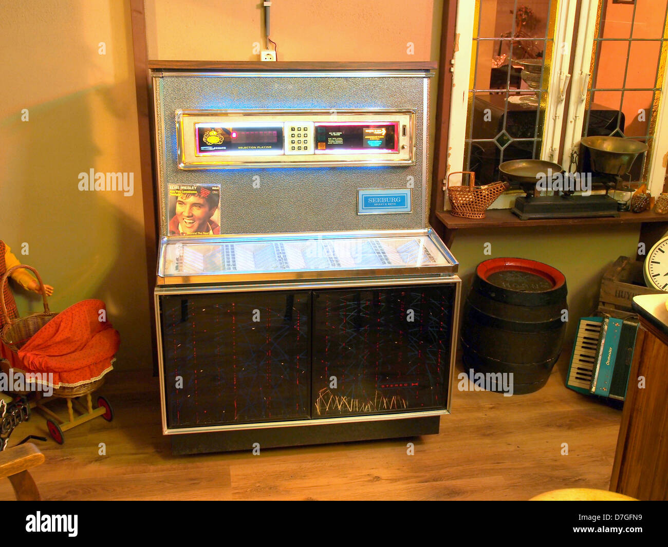 Die Seeburg Select-O-Matic Jukebox, ein klassisches Unterhaltungsgerät aus der Mitte des 20. Jahrhunderts, bot Musikliebhabern die Möglichkeit, Schallplatten auszuwählen und abzuspielen. Bekannt für ihr schlankes Design und ihre mechanische Innovation, wurde die Jukebox zu einer kulturellen Ikone ihrer Zeit und spiegelt die Musik und sozialen Trends dieser Zeit wider. Stockfoto