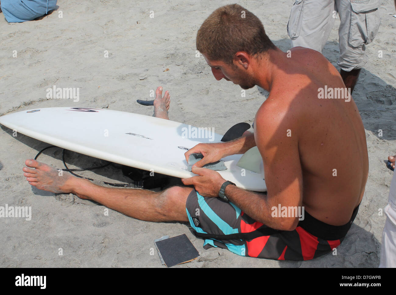 Eine Szene aus Spice Küste Indien Surfen und SUP Meisterschaft Kovalam Beach, Indien. Wettbewerber, die Reparatur seiner Surf board Stockfoto