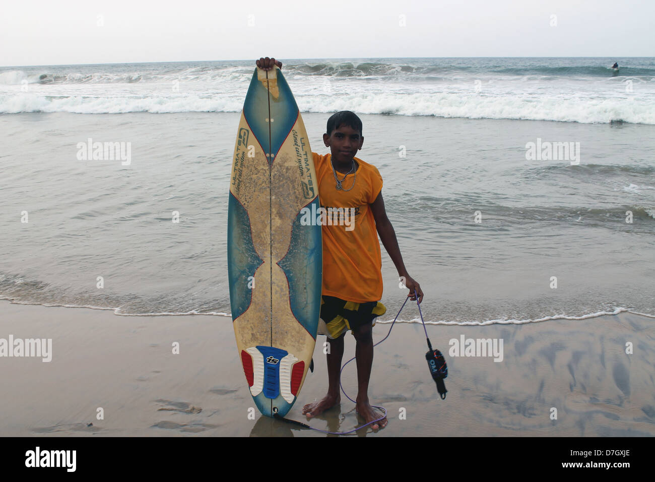 Ein Kind-Surfer posiert für Fotos mit seinem Surf-Brett Stockfoto