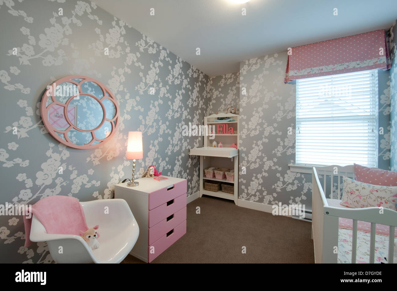 Moderne Kinderzimmer mit Babybett und rosa Einrichtung. Stockfoto