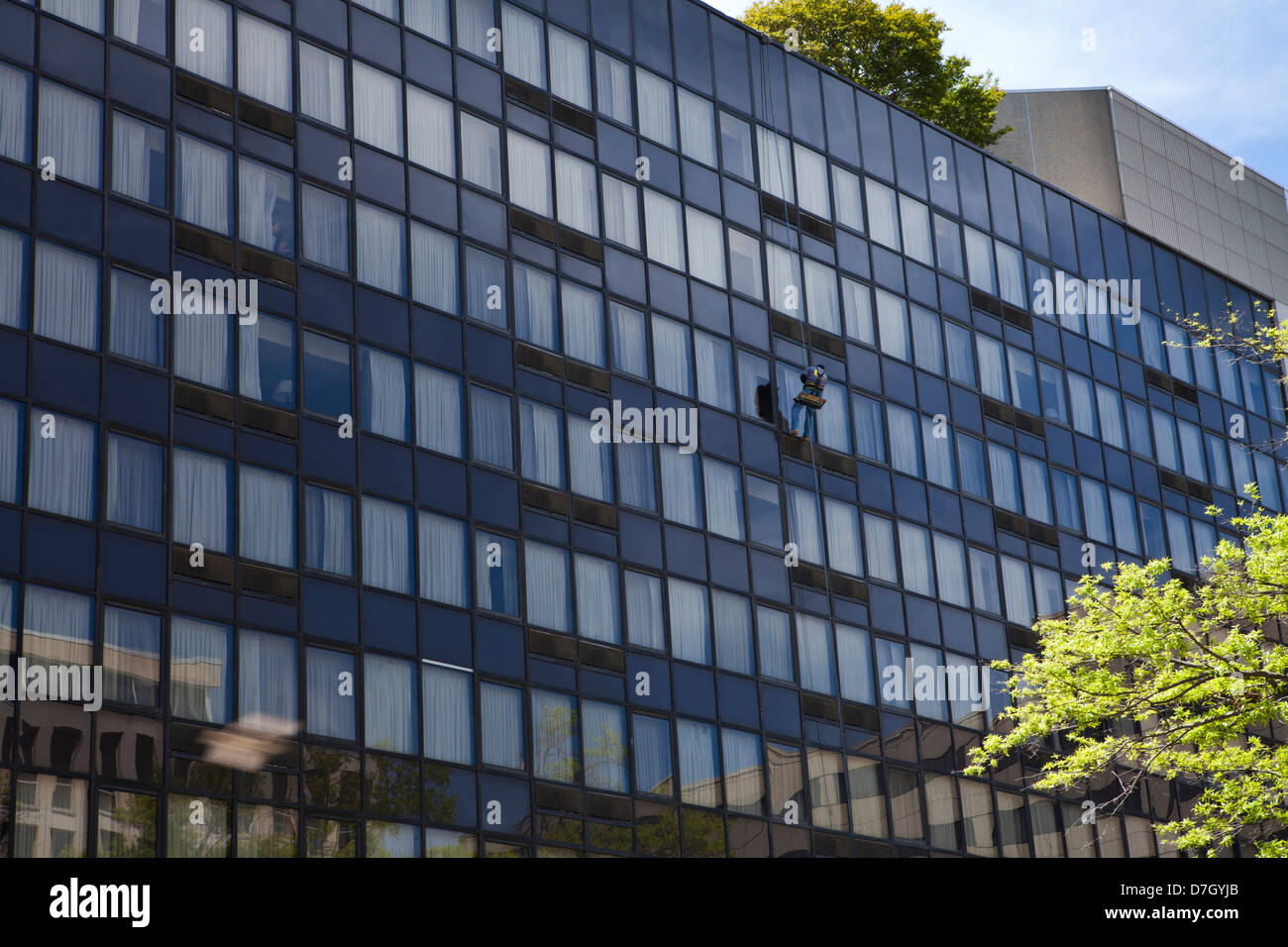 Mann arbeitet in der Bootsmann Stuhl auf Glasbau - USA Stockfoto