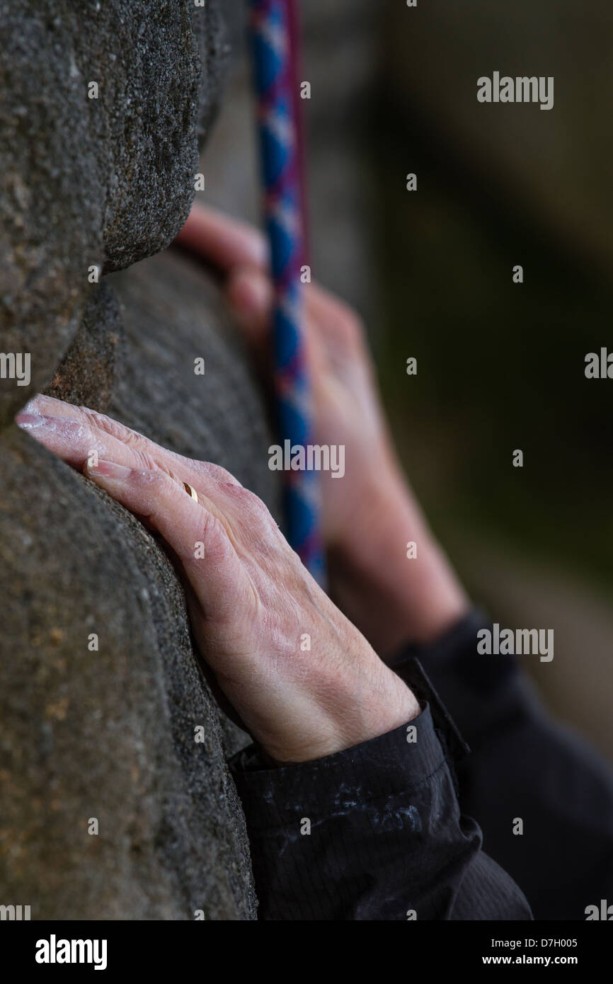 Die Kalkhaltigen weiblichen Kletterer Hände auf gritstone Rock Stockfoto