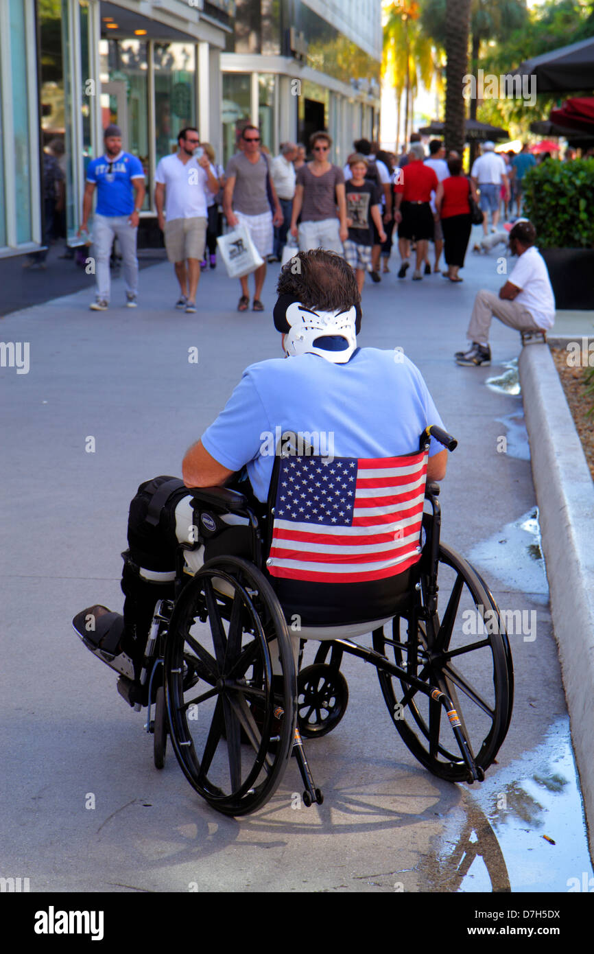 Miami Beach, Florida, Lincoln Road Mall, Männer, Erwachsene Erwachsene, Rollstuhl, Behinderte, besondere Bedürfnisse, Nackenstütze, Flagge, FL121116006 Stockfoto