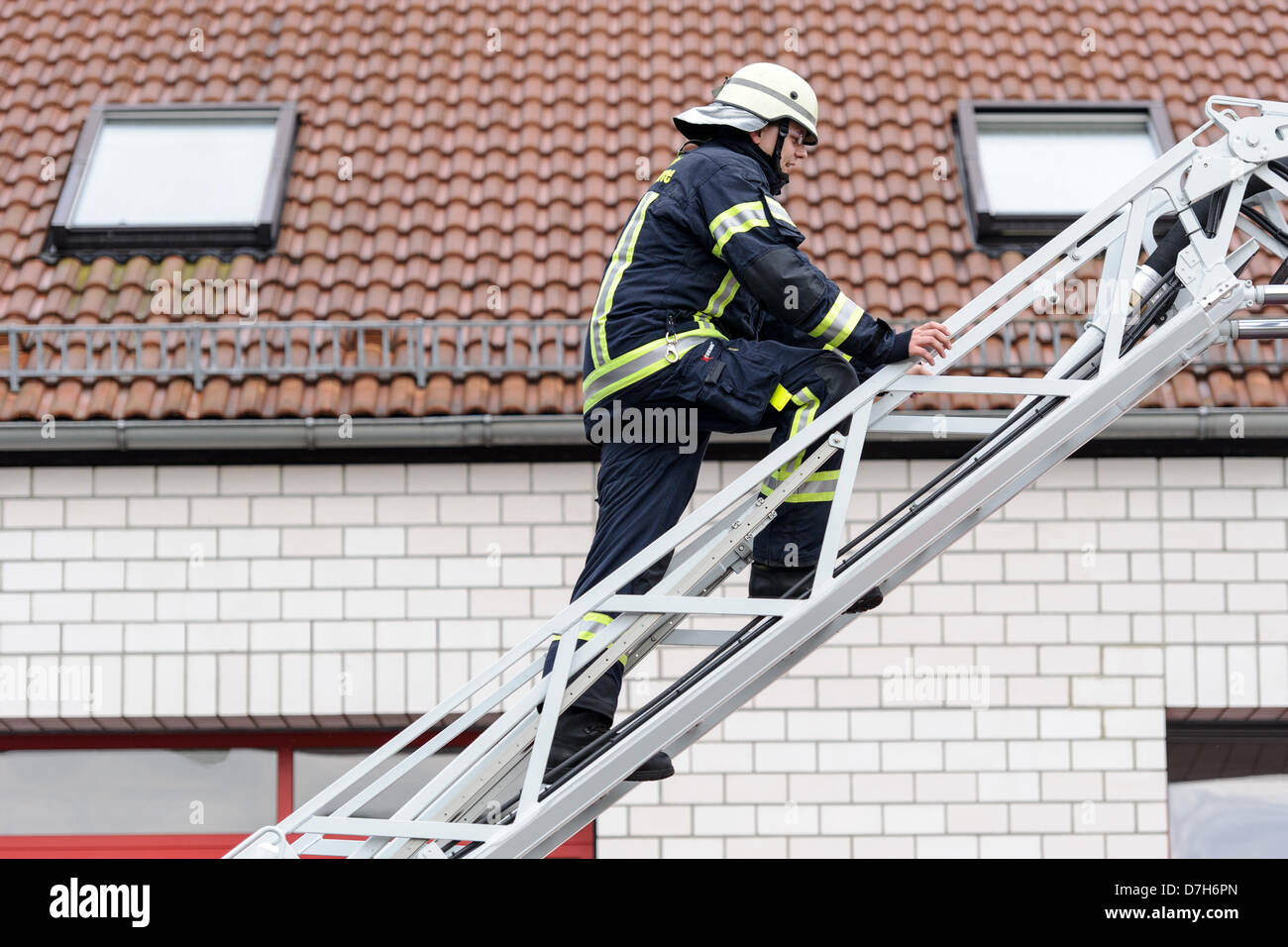 Ein Feuerwehrmann klettert eine Leiter. Foto: Robert Schlesinger  Stockfotografie - Alamy