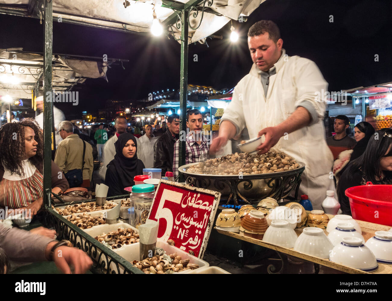 Marokko, Marrakesch - Nachtmarkt und Food Stände in Jamaa el Fna nach Einbruch der Dunkelheit. Gekochte Schnecken zu essen. 5 Euro pro Schale. Stockfoto