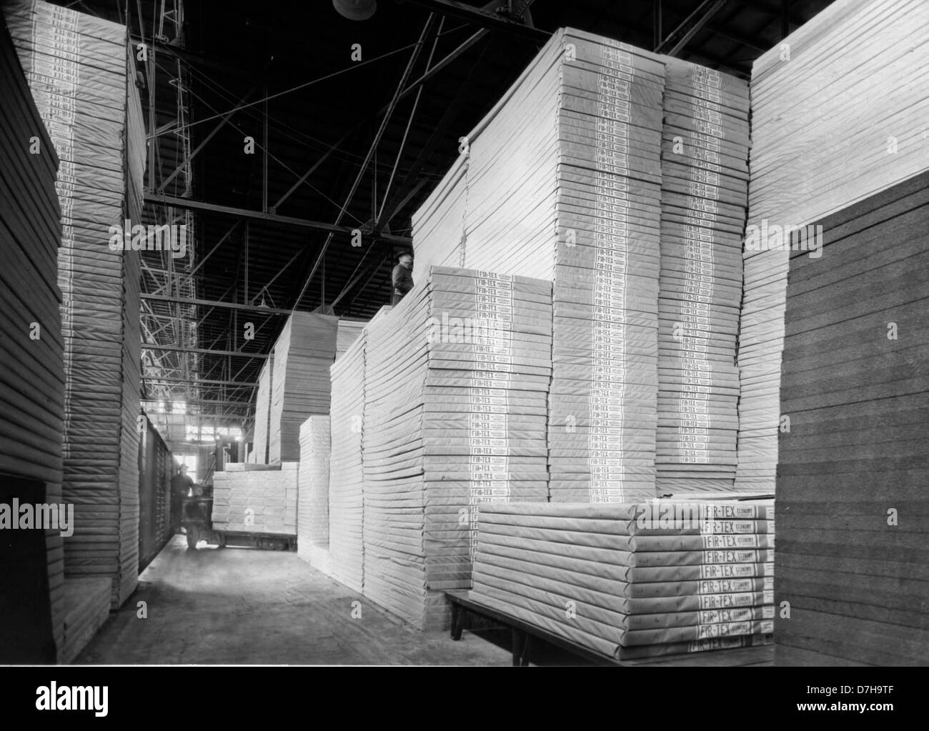 Ein historisches Bild aus dem OSU-Archiv, das Fir Tex Manufacturing in Oregon um 1940 zeigt. Die Fabrik spezialisierte sich auf die Herstellung von Faserplatten, was die staatliche Beteiligung an der Forstwirtschaft und der Produktion während dieser Zeit widerspiegelt. Stockfoto