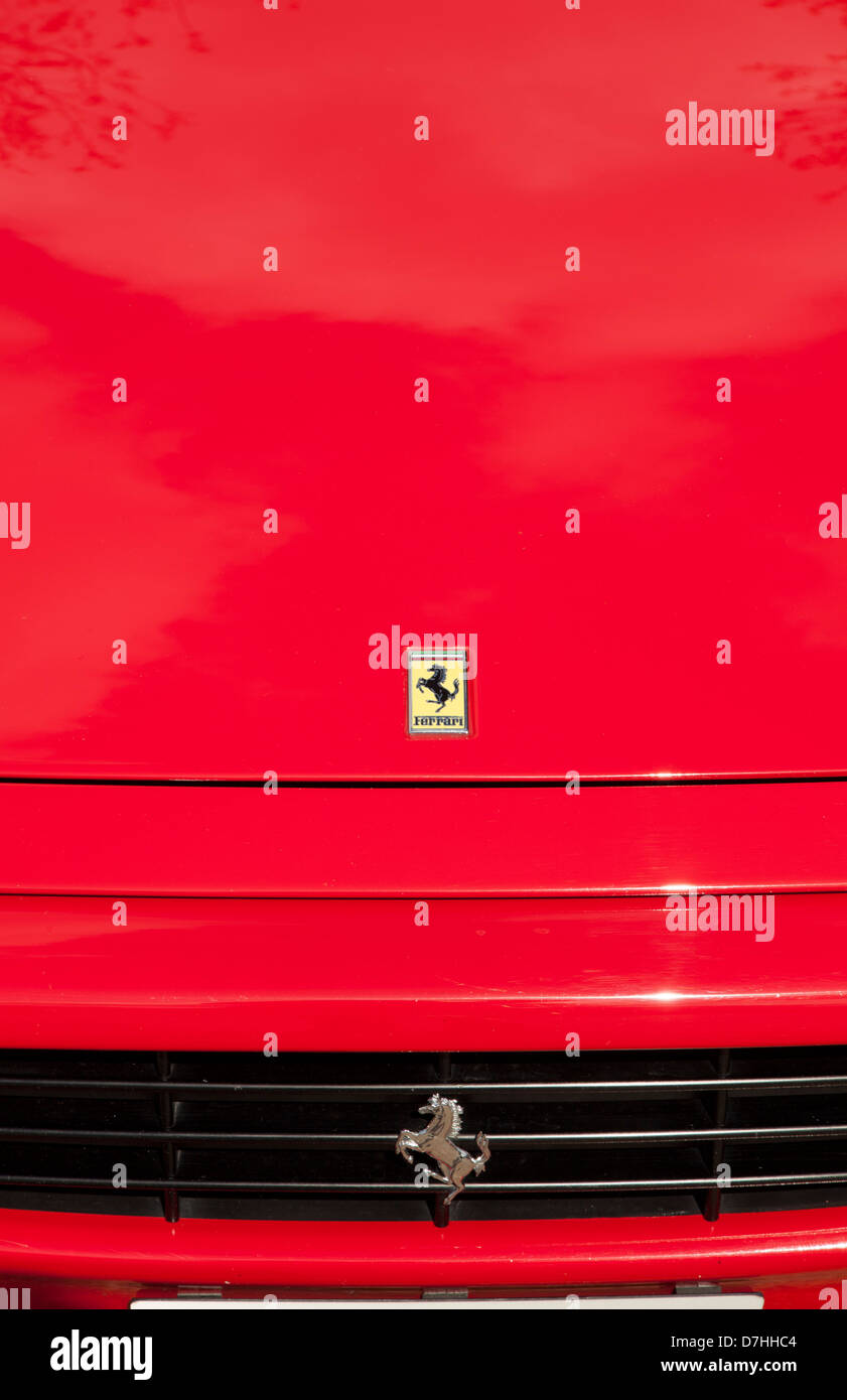 Roter Ferrari 350 Spyder zeigt Pferd Ferrari Emblem auf Motorhaube. Chrom-Pferd auf dem Grill. Stockfoto