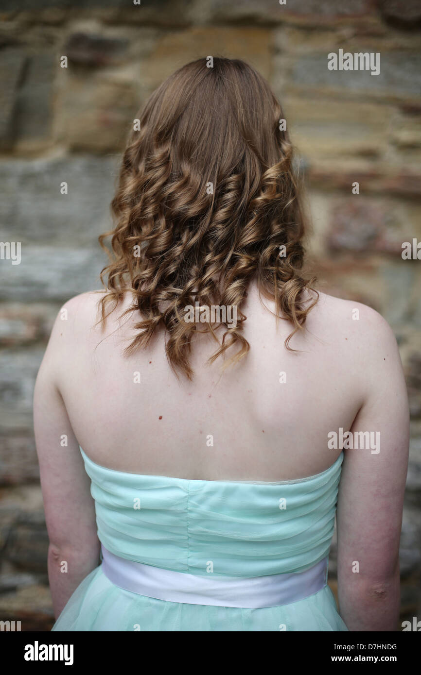 Eine junge Frau mit locken, in einem Kostüm, wie von hinten gesehen. Stockfoto