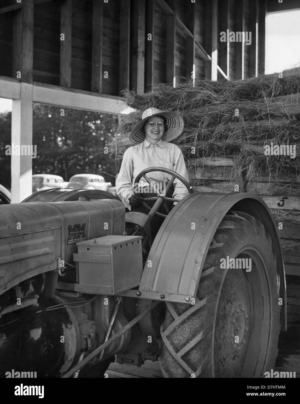 Dieses historische Foto aus dem Jahr 1944 zeigt Elsie Hill, der einen Traktor im Benton County, Oregon, bedient. Das Bild fängt das ländliche Leben der Zeit und die Rolle der Frauen in der Landwirtschaft während des Zweiten Weltkriegs ein Stockfoto
