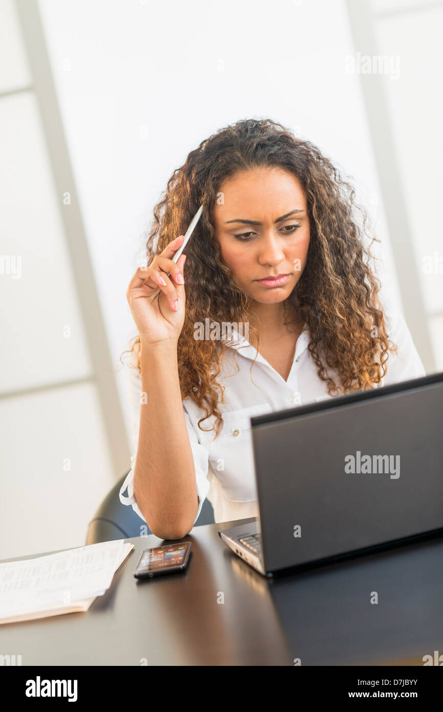 Büroangestellte sitzen Schreibtisch mit laptop Stockfoto