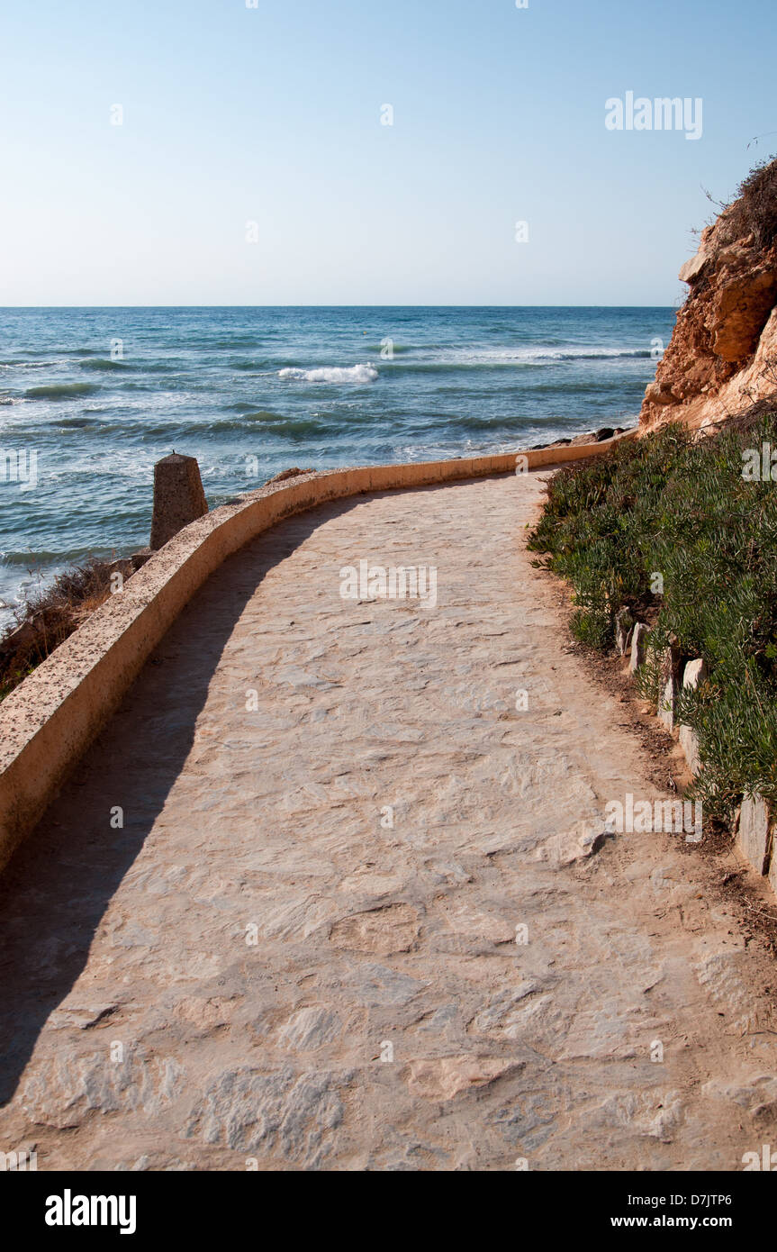 Gebogene Kopfsteinpflaster gepflasterten Weg entlang der Küste. Stockfoto