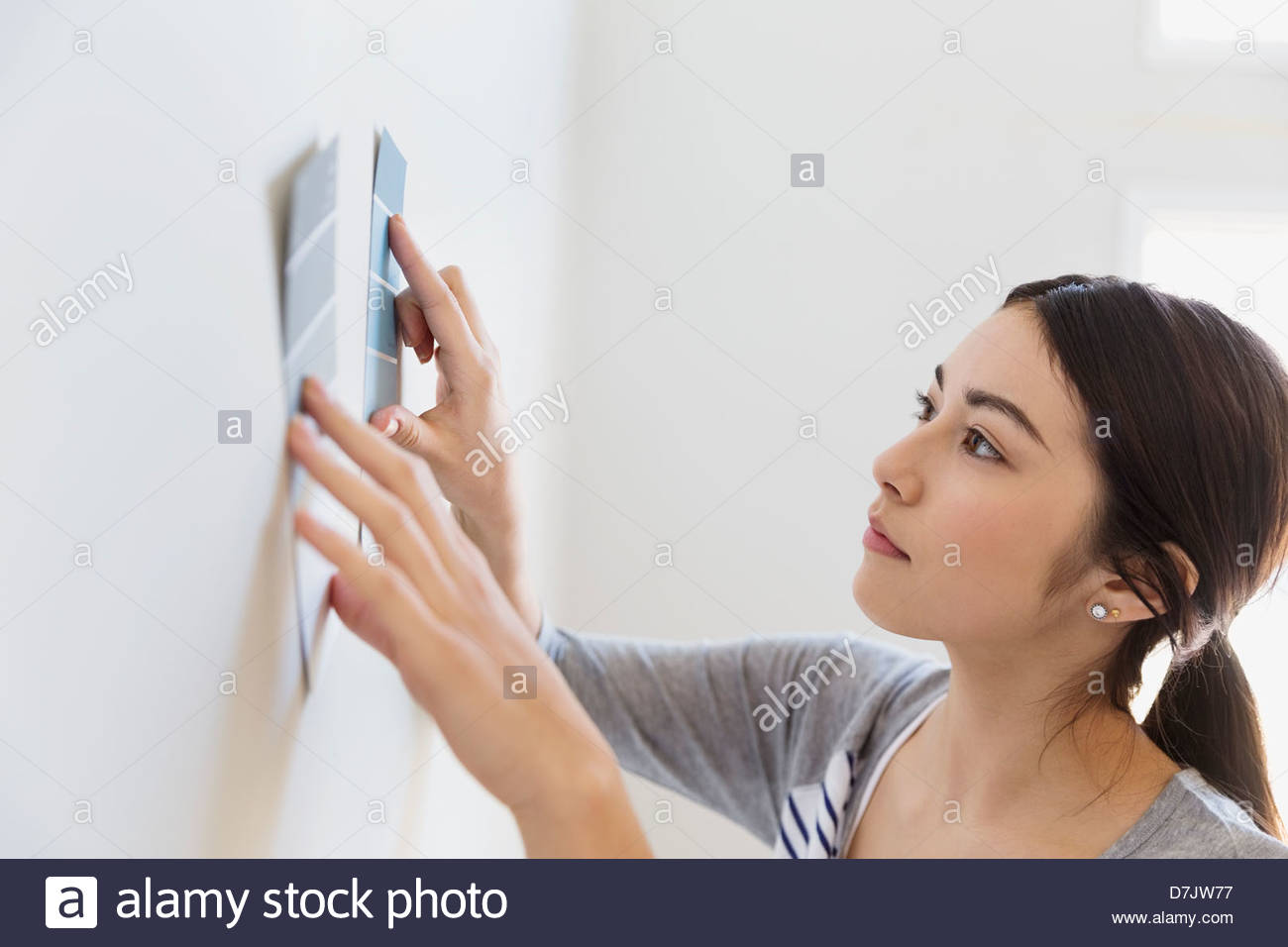 Junge Frau, die Auswahl der Farbenfarben zu Hause Stockfoto