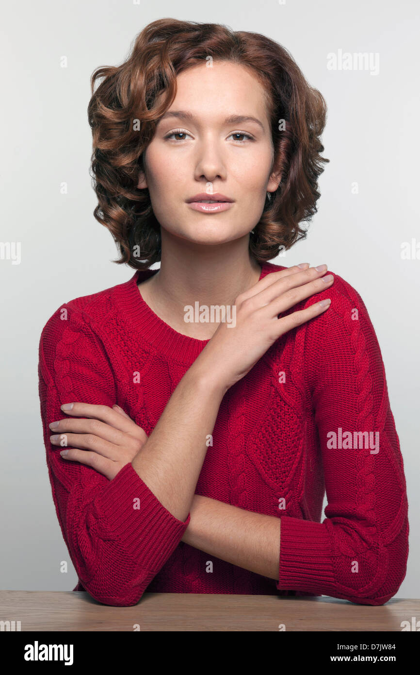 Studio Portrait junge Frau im roten Pullover gedreht Stockfoto