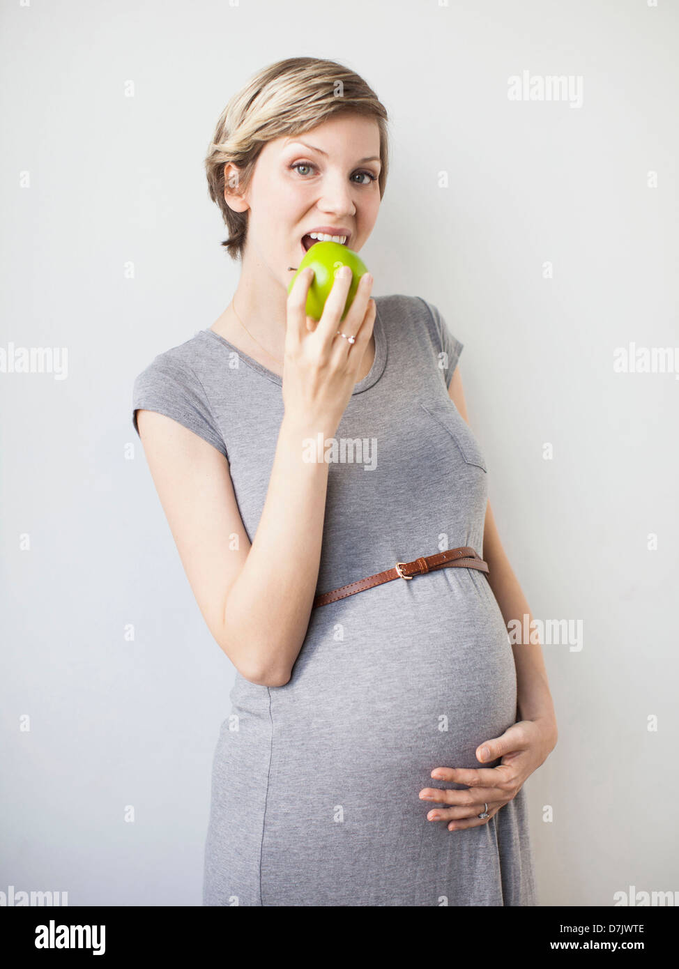 Studioaufnahme der schwangeren Frau Essen Apfel Stockfoto