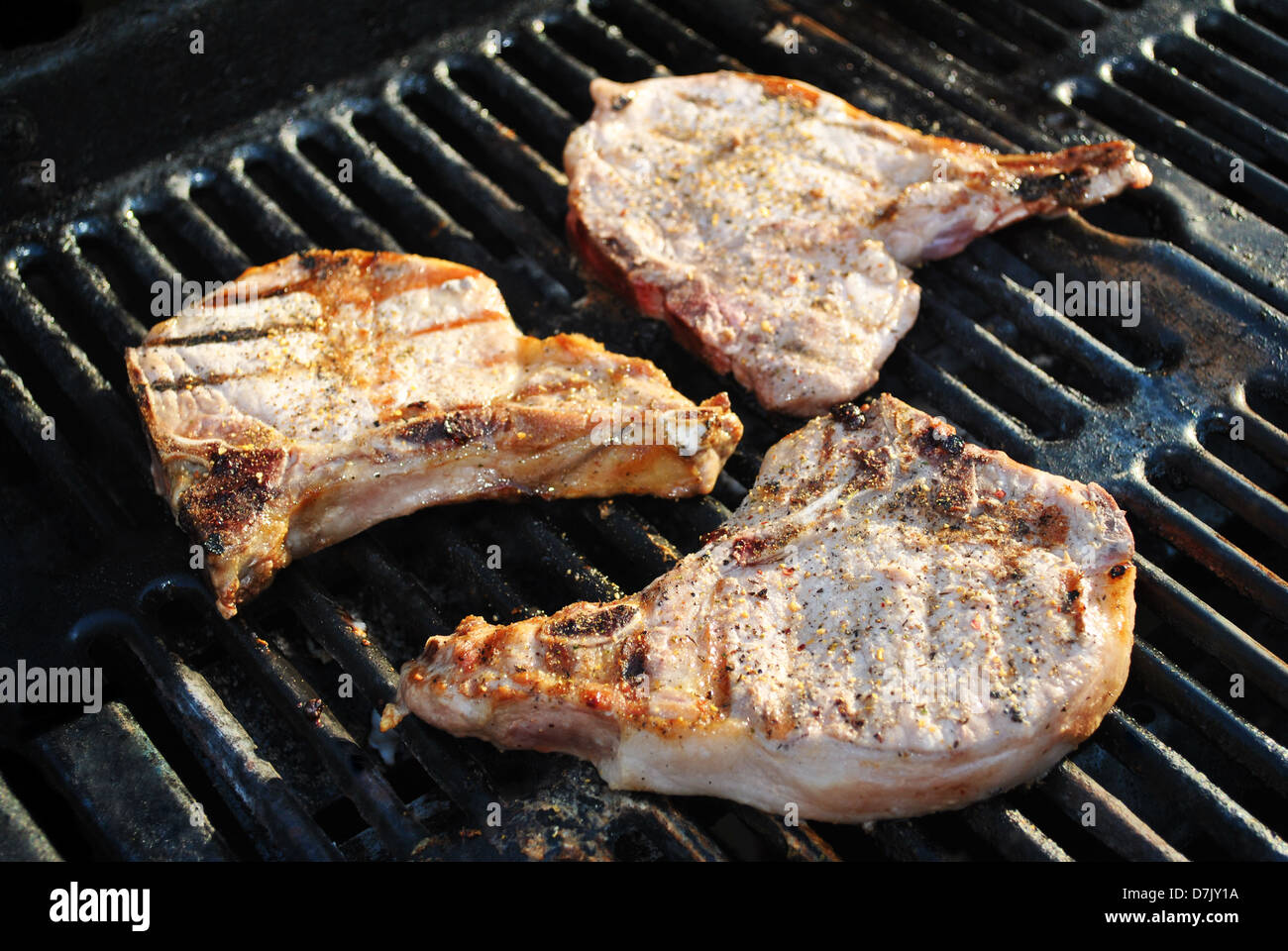 Drei gekochte Porkchops auf einem Sommer-Grill Stockfoto