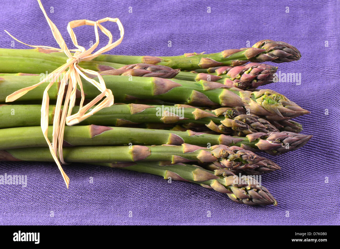 Frischen rohen Spargel Haufen auf lila Serviette im Querformat Stockfoto