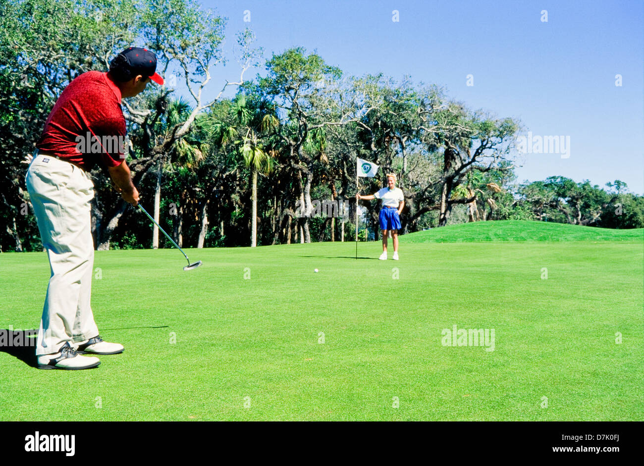 Paar, Golfen, männlichen Golfer schlagen Ball, Miami Stockfoto