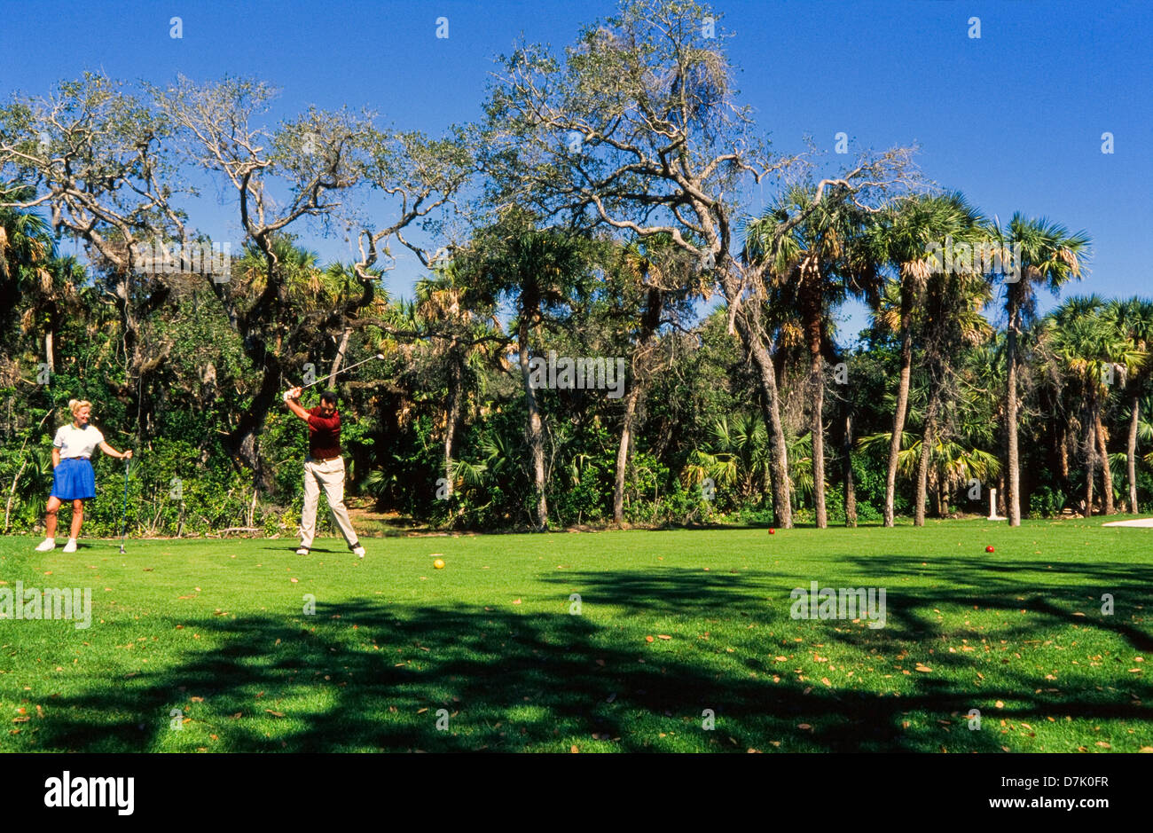 Paar, Golfen, männlichen Golfer schlagen Ball, Miami Stockfoto
