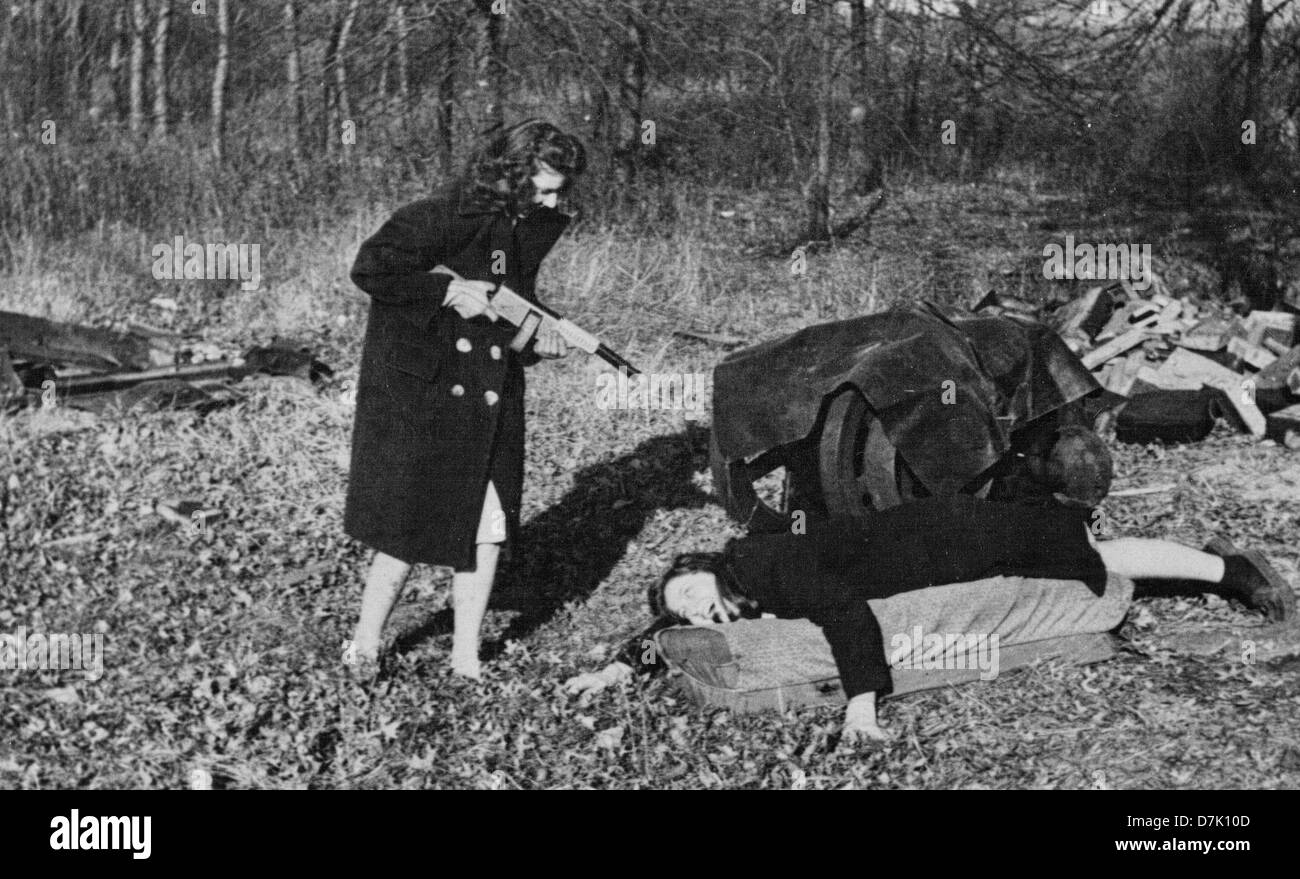 Frau hält gefälschte Maschinengewehr auf paar auf dem Boden, USA, ca. 1940 Stockfoto
