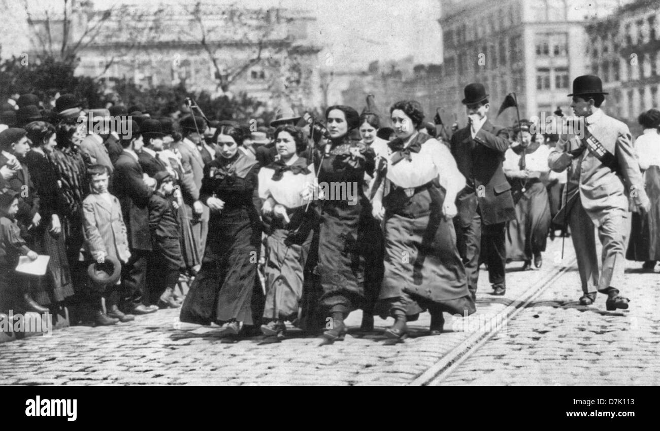 May Day Parade, New York, 1910.  Zeigt mehrere Männer und Frauen gehen durch die Menge; vier Frauen marschieren Arm in Arm im Vordergrund. Stockfoto