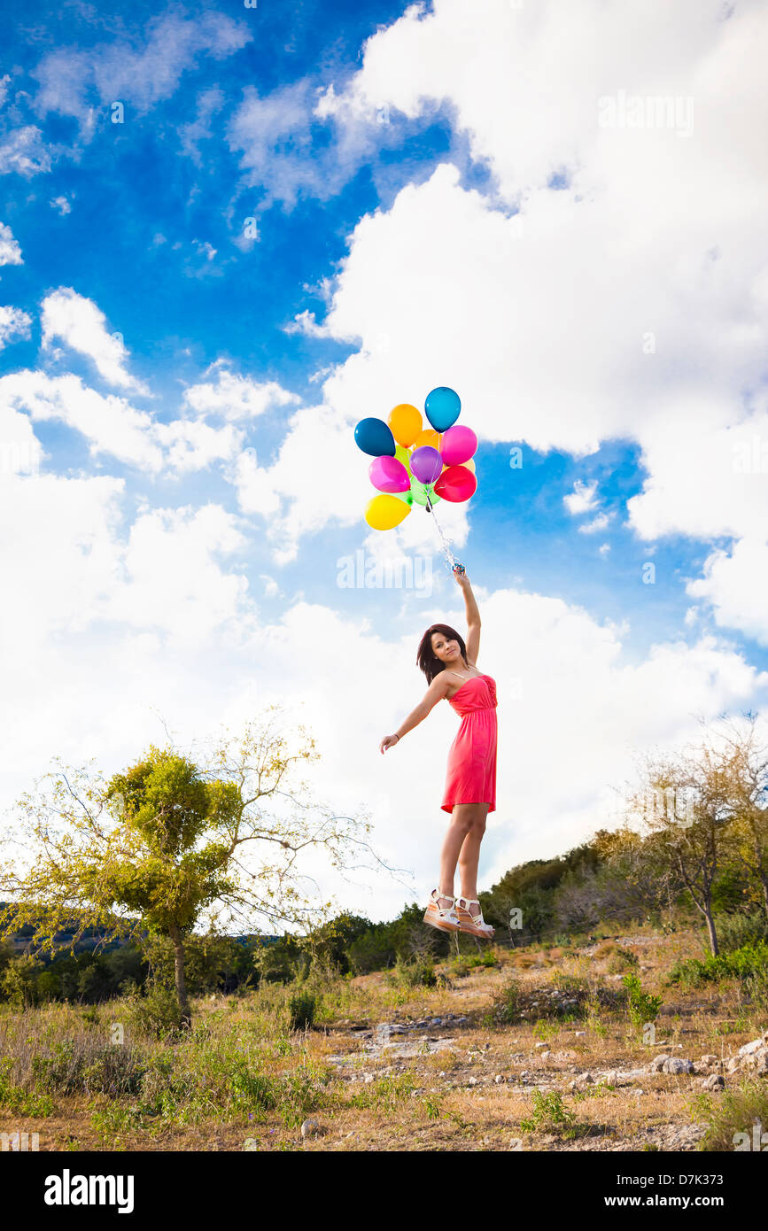USA, Texas, junge Frau mit Luftballons fliegen Stockfoto