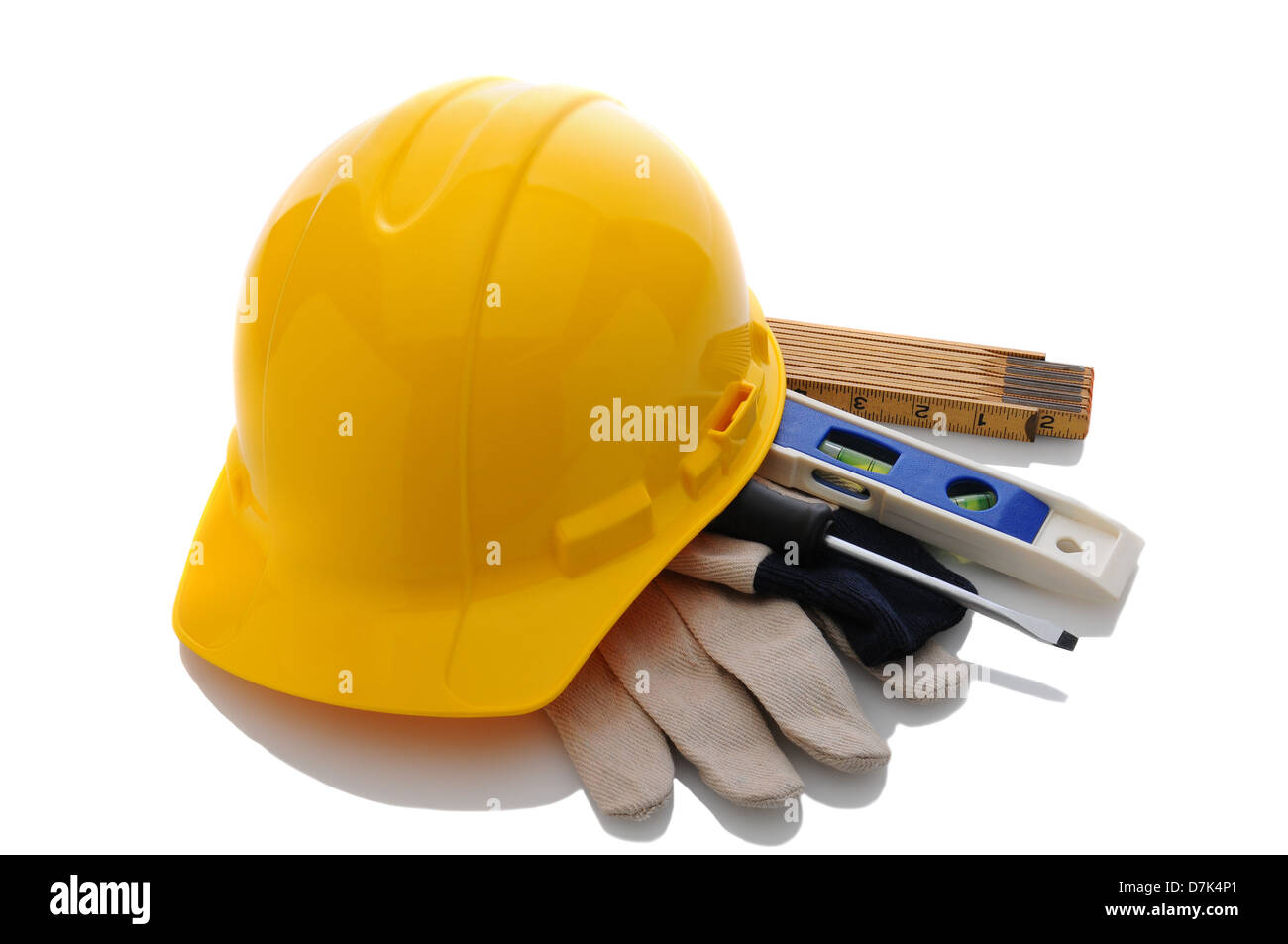 Eine gelbe Auftragnehmer Schutzhelm Arbeitshandschuhe und Tools. Querformat in weiß mit Reflexion. Stockfoto