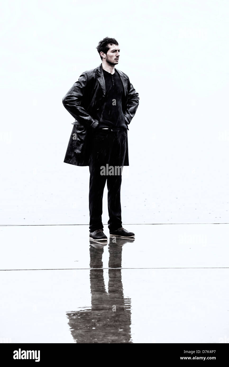 ein finsterer Mann in einer schwarzen nass Lederjacke bei Regen Stockfoto