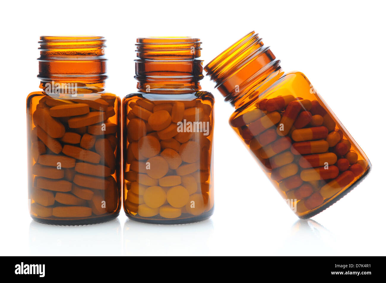 Drei braune Rezept-Medizin-Flaschen auf einer weißen Fläche mit Reflexion. Stockfoto