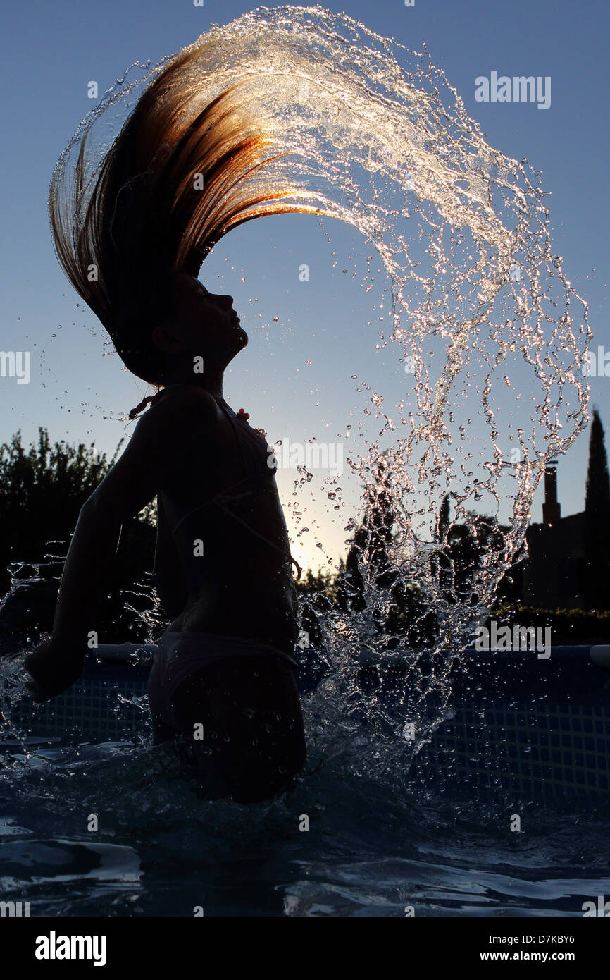 Torre Alfina, Italien, Silhouette, Mädchen wirft ihr nasses Haar wieder im Schwimmbad Stockfoto
