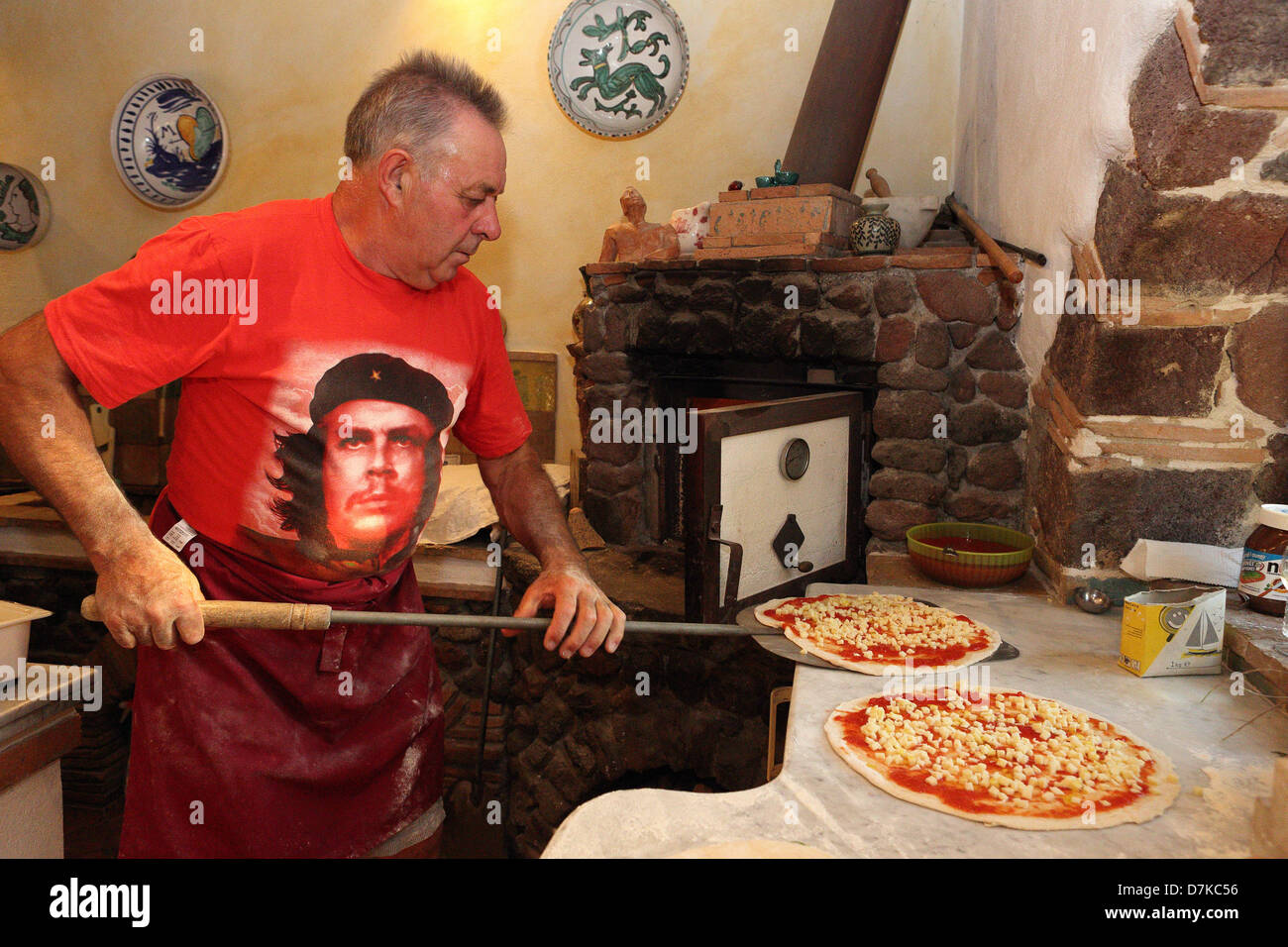 Torre Alfina, Italien, Pizzabäcker schiebt eine Pizza auf einem Backblech Folie Stockfoto