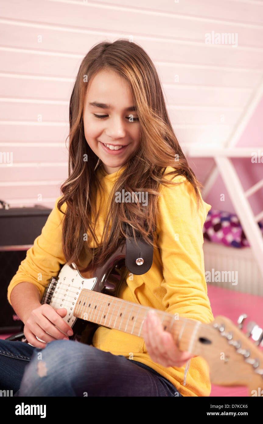 Mädchen spielt Gitarre, Lächeln Stockfoto