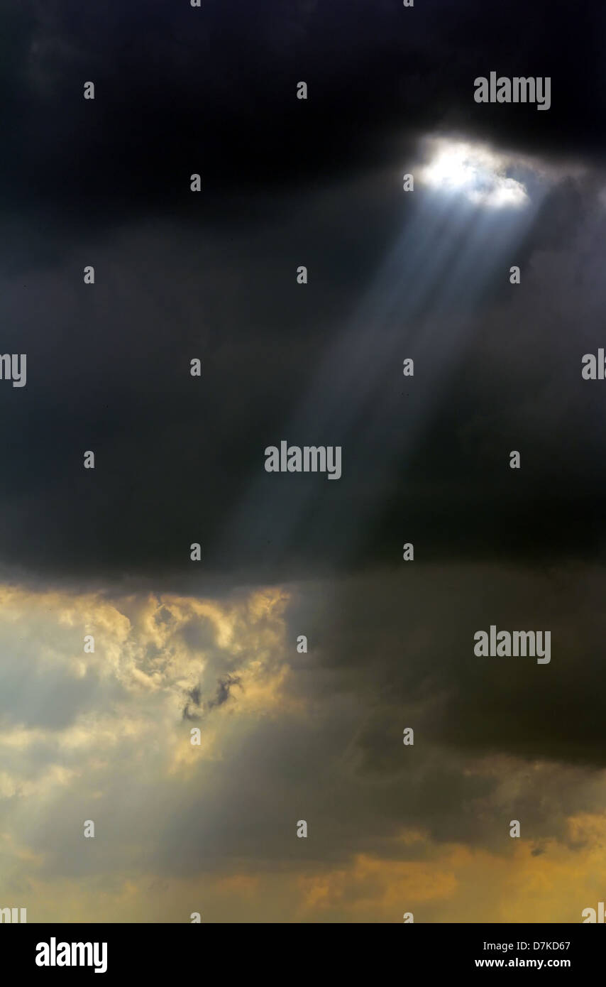 Sonnenstrahl durch die schwarzen Wolken vor dem Sturm. Stockfoto