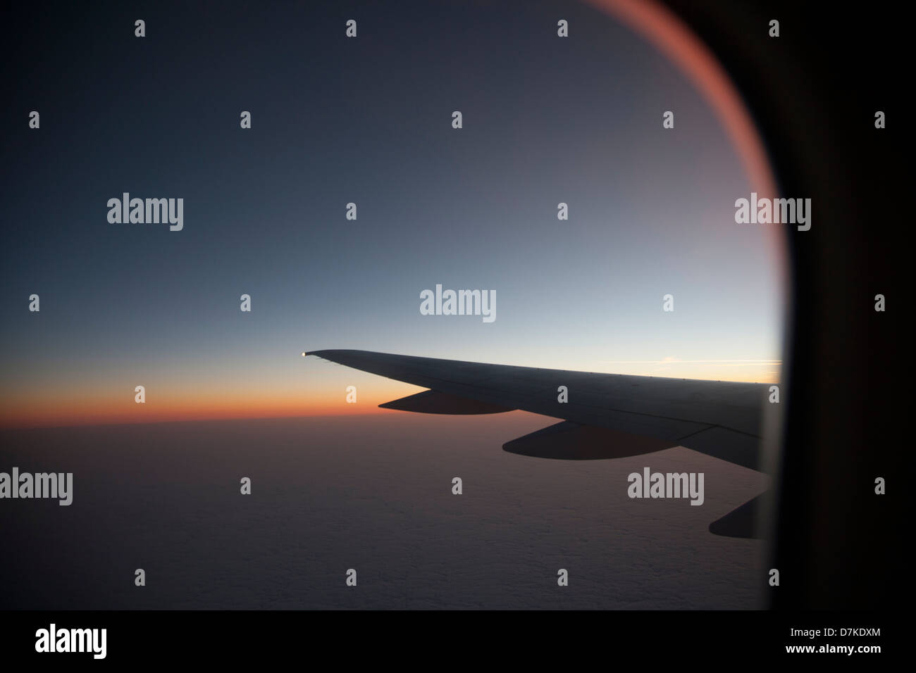 Blick auf den Sonnenuntergang von einem Flugzeugfenster Stockfoto