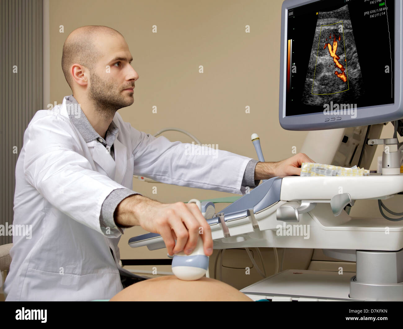 Porträt des jungen männlichen Techniker Betrieb Ultraschallgerät im weißen Kleid Stockfoto