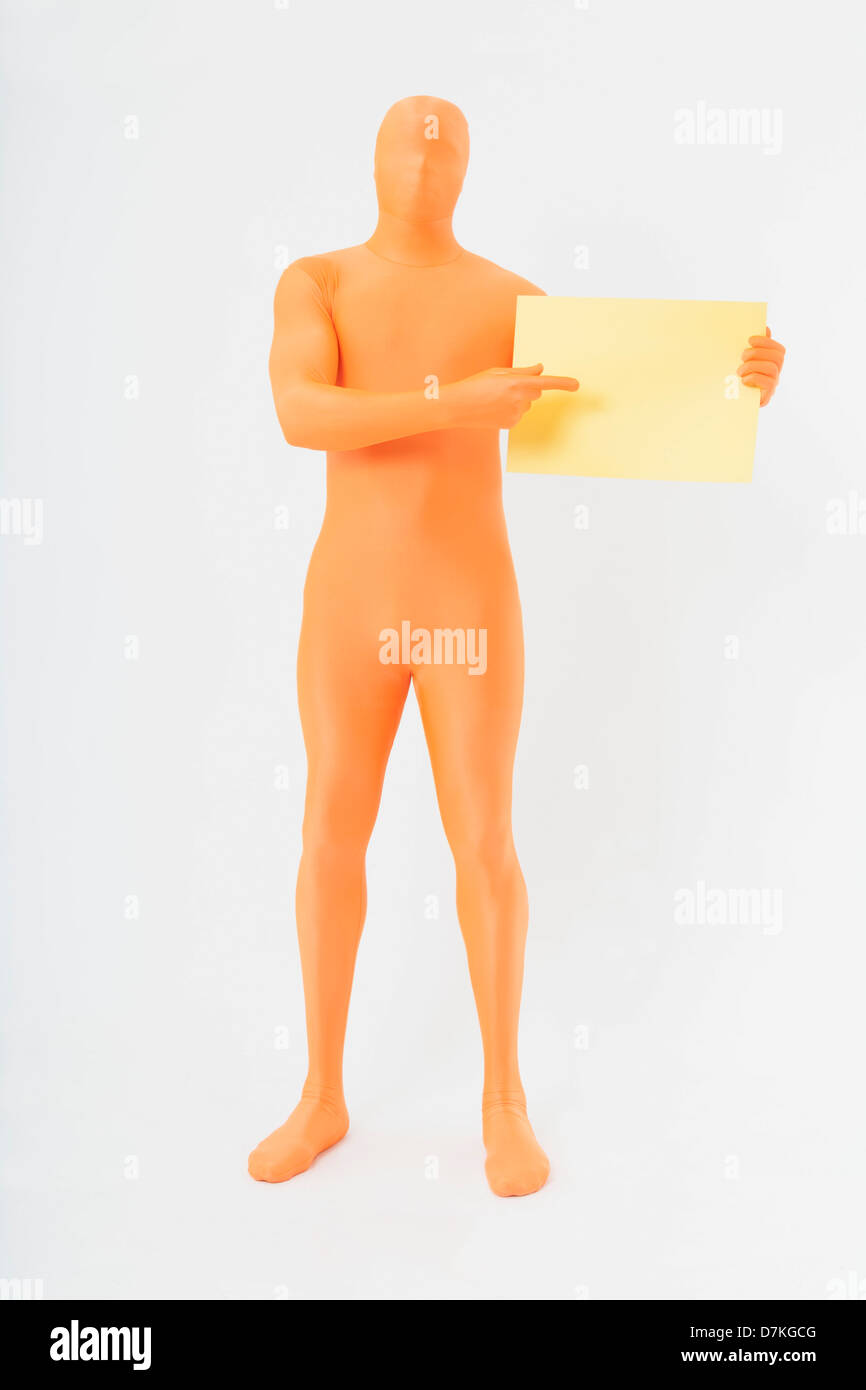 Reifer Mann in orange Zentai hält leere Seite auf weißem Hintergrund Stockfoto