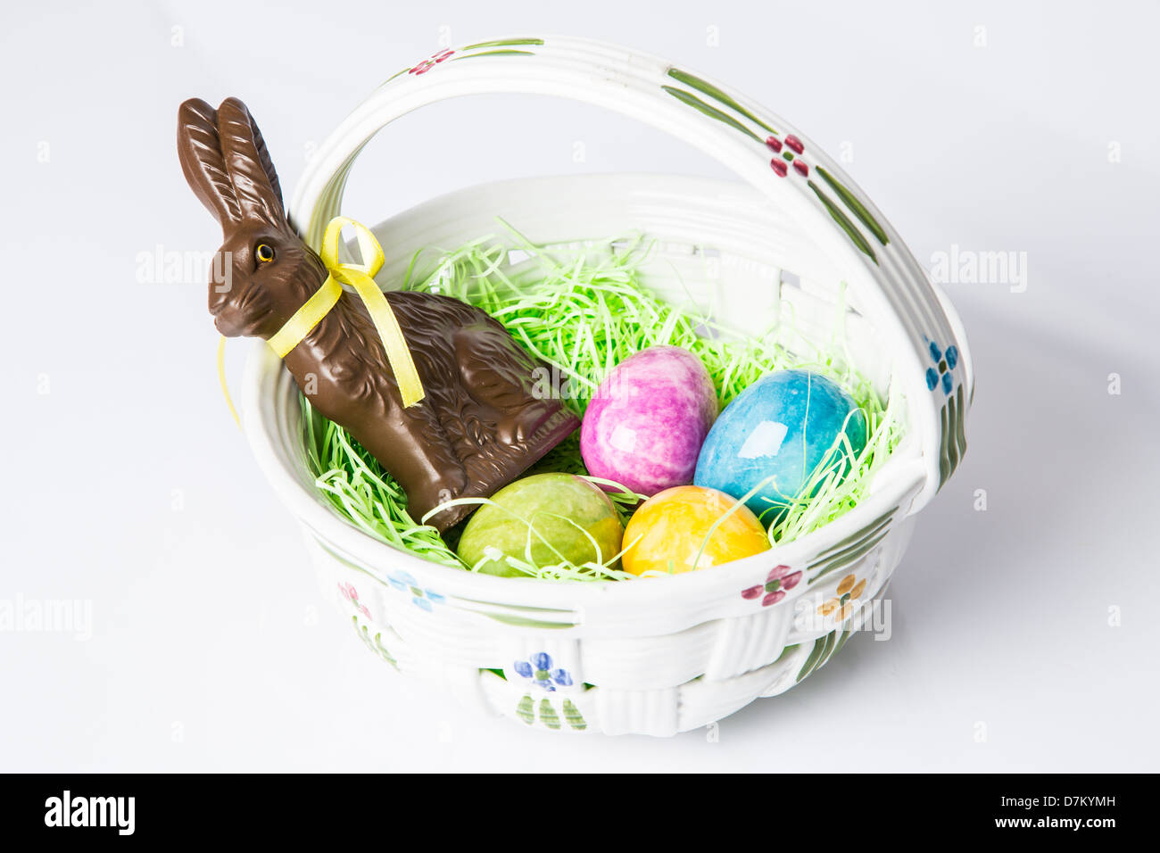 Ostereier und ein Schokolade Hase in einem keramischen Korb. Weihnachtstraditionen Stockfoto