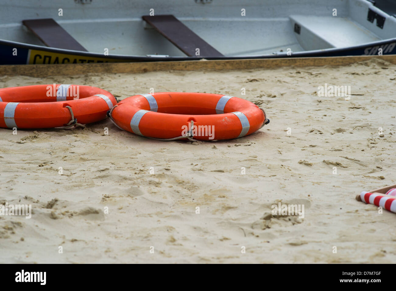 Rettungsboot und Ringe auf dem nassen Sand des Strandes. Stockfoto