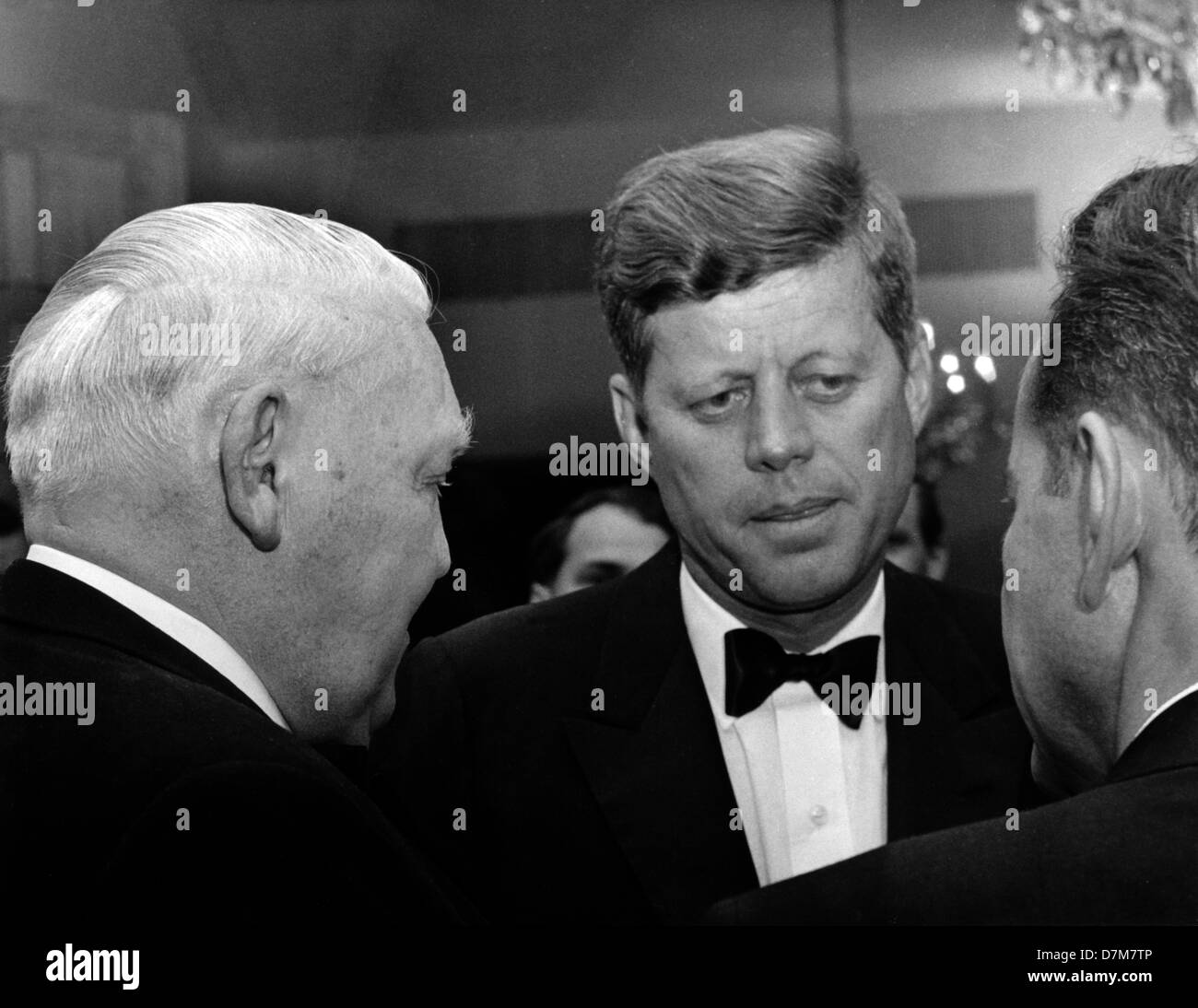 US-Präsident John F. Kennedy (m) spricht mit seinen Gästen bei einem Empfang organisiert zu seinen Ehren im Palais Schaumburg in Bonn am 23. Juni 1963. Hier spricht er mit Bundes-Wirtschaftsminister Ludwig Erhard (l, Rückansicht). Präsident Kennedy war die Bundesrepublik für vier Tage zu Besuch. Stockfoto