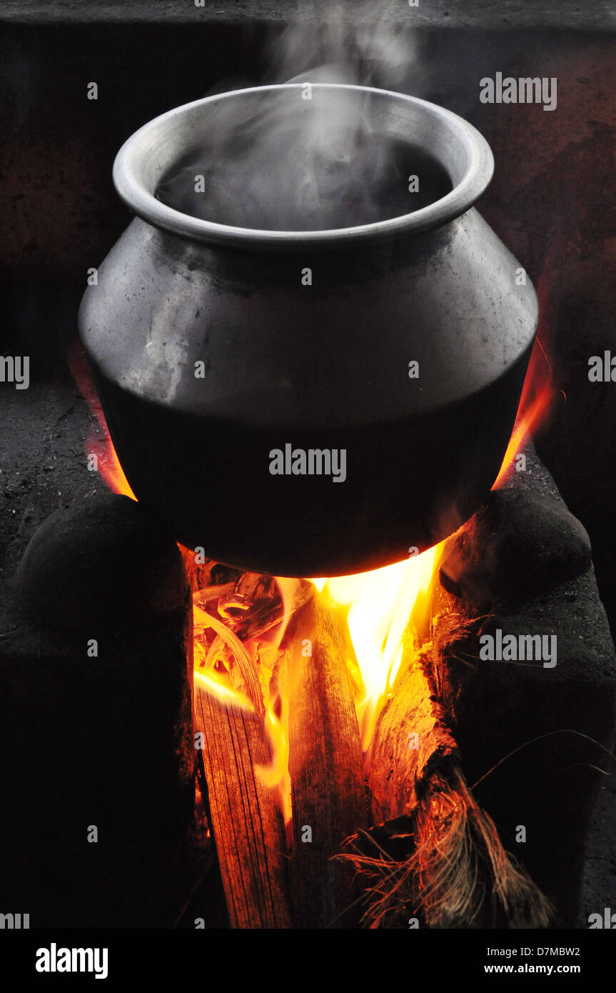 Kochendes Wasser in einem Topf aus Aluminium über das Feuer in einem Kamin. Stockfoto