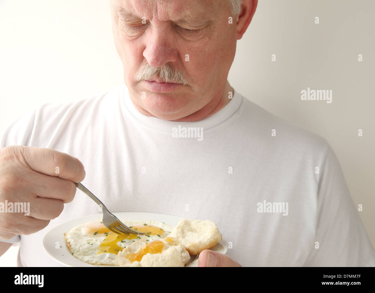 älterer Mann sein Frühstück Essen Stockfoto
