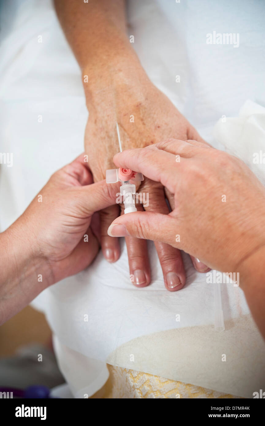 Krankenschwester, die Vorbereitung eines Patienten auf eine IV-Leitung Stockfoto