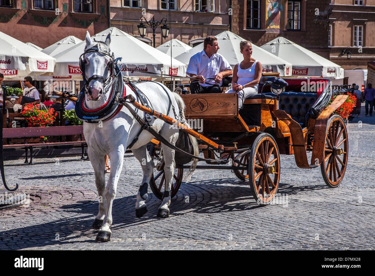 Ein weiblicher Touristen fährt in einer Pferdekutsche an einem sonnigen Sommertag in Stary Rynek, alte Stadt-Marktplatz in Warschau, Polen. Stockfoto