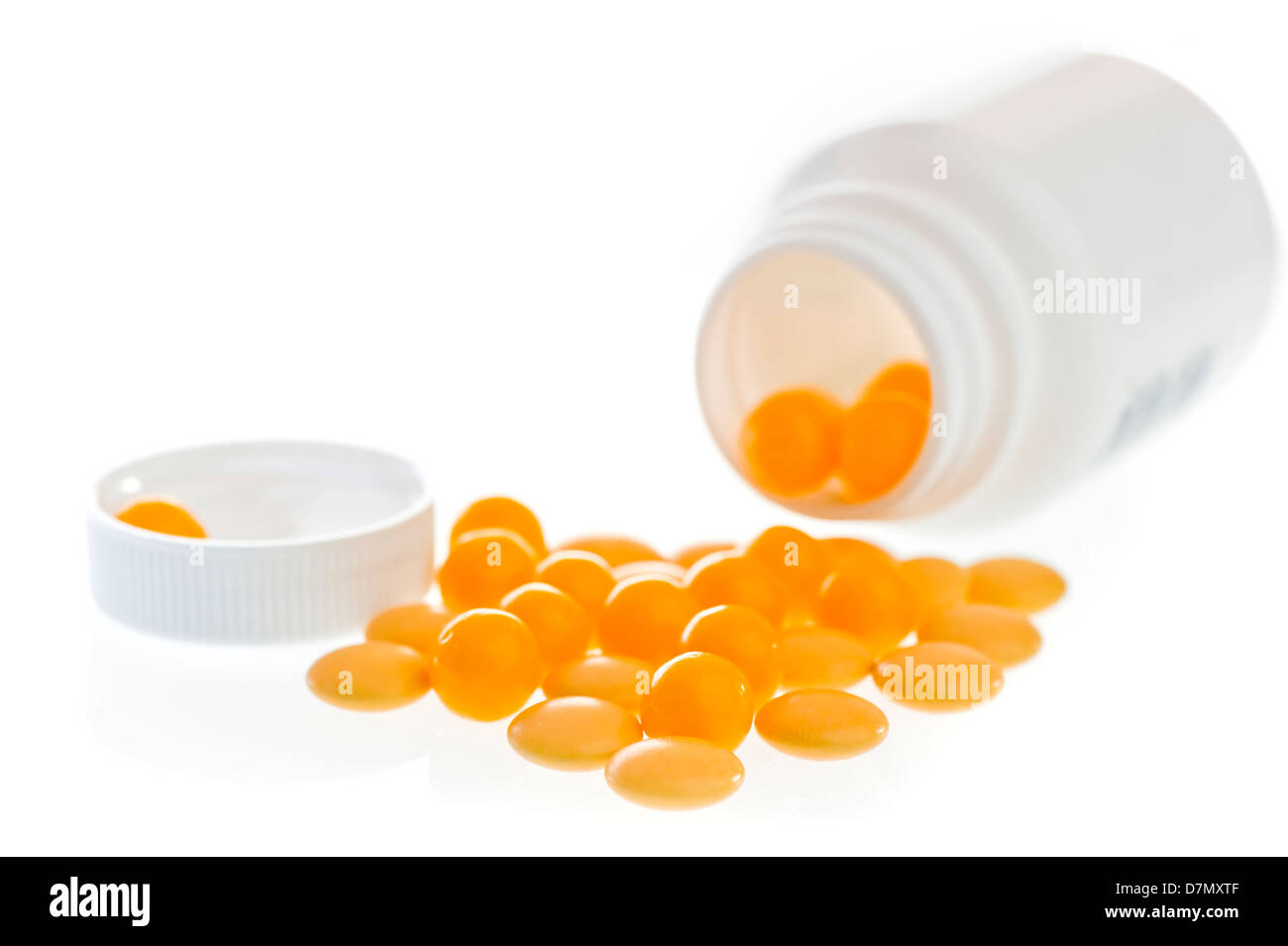 Gelbe Pillen verstreut vor den weißen Kunststoff-Glas. Stockfoto