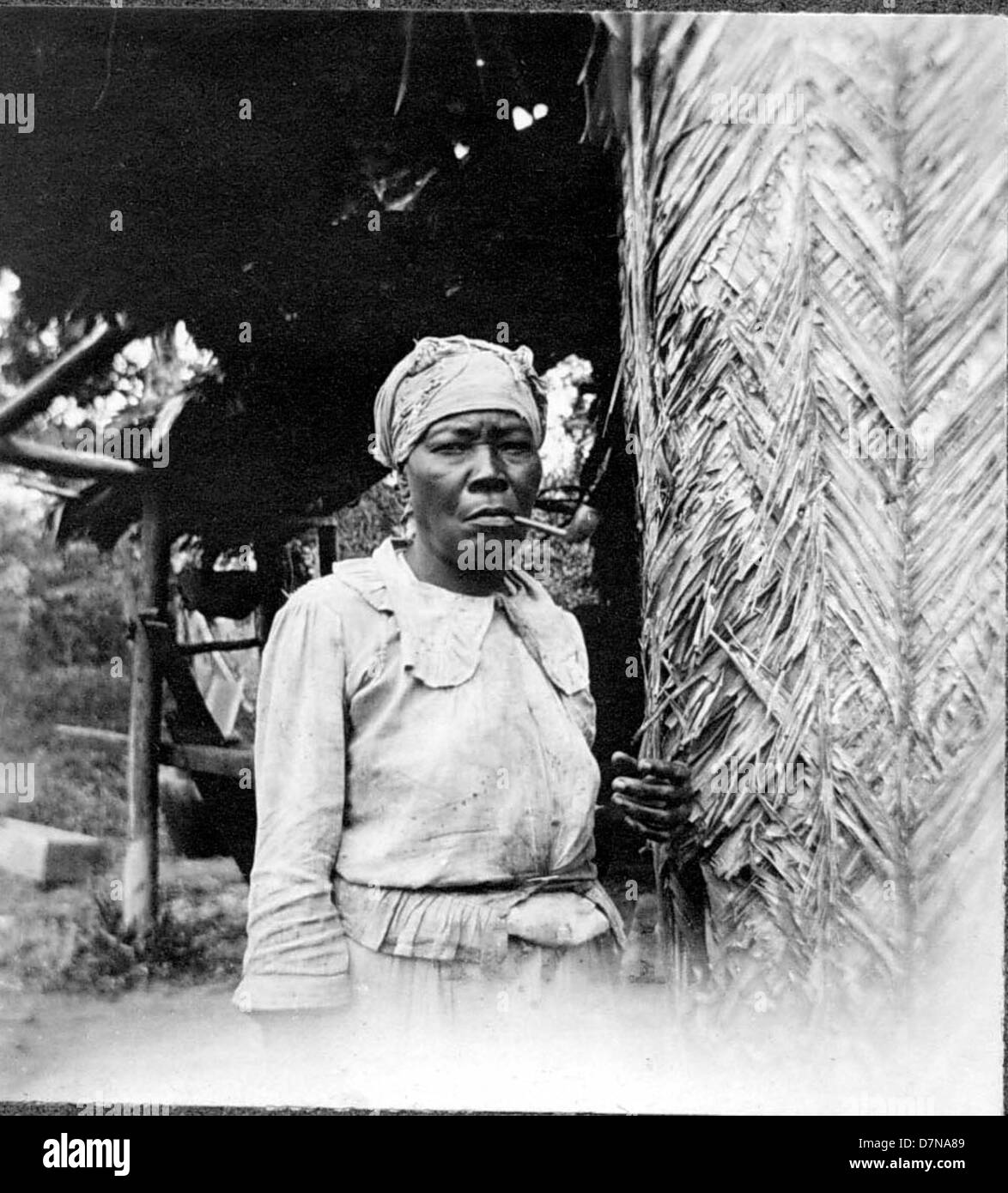 Eine Frau wird 1922 während der Stanley Field Expedition in Britisch-Guayana beim Pfeifenrauchen fotografiert. Das Bild dokumentiert das tägliche Leben und die botanische Erforschung Südamerikas. Stockfoto